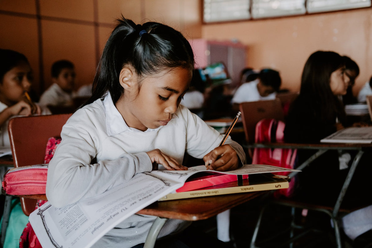girl doing work in school desk